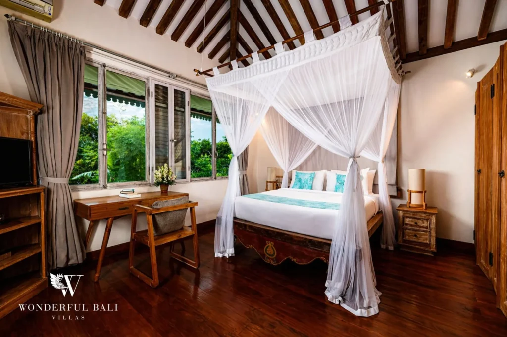 Four-poster canopy bed in a traditional Balinese bedroom with teak floor, Villa Hasian in Jimbaran