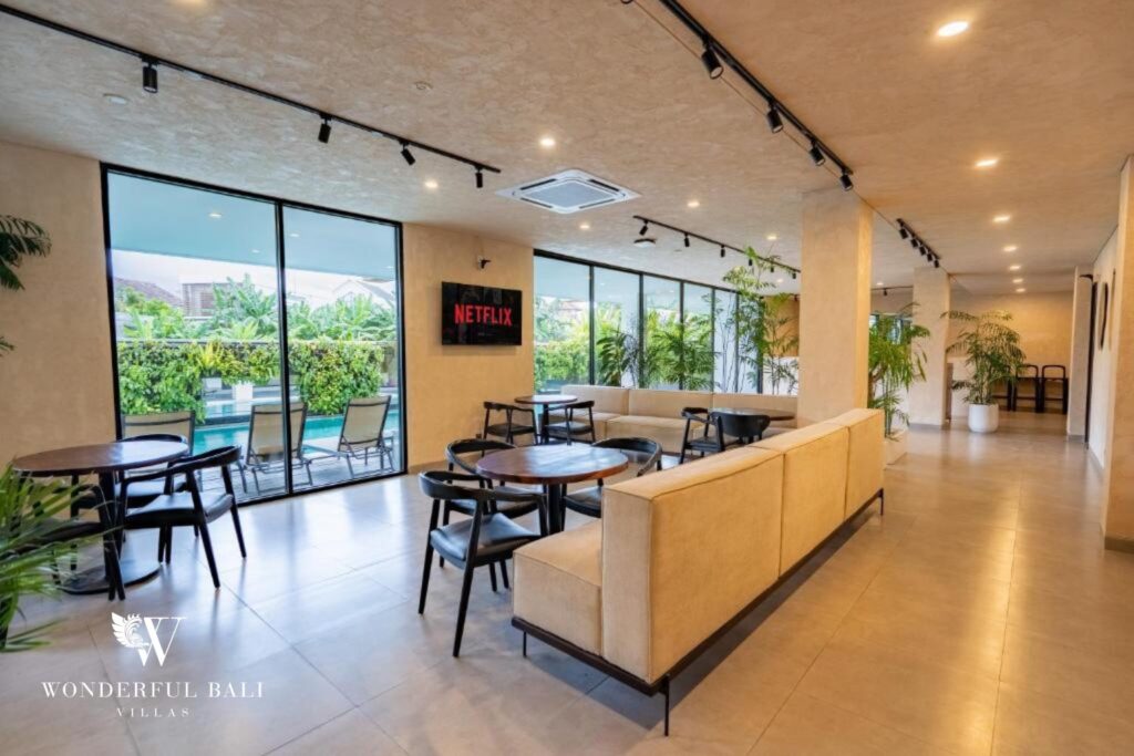 Shared co-working and lounge area with tables and smart TV, modern apartment building in Canggu