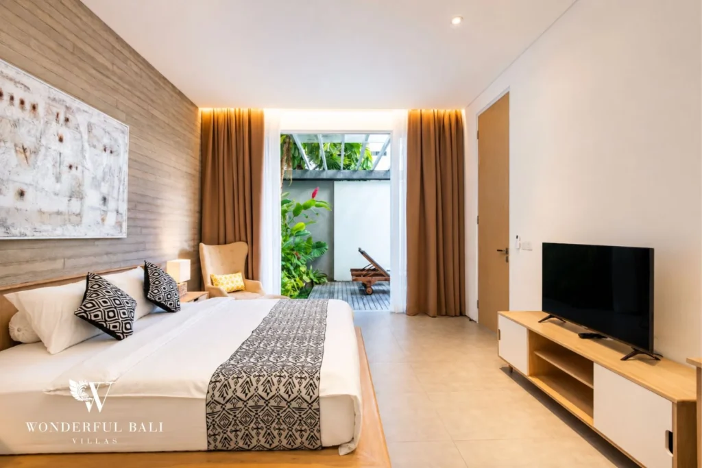 Bedroom with TV and garden access at a villa in Petitenget, Bali