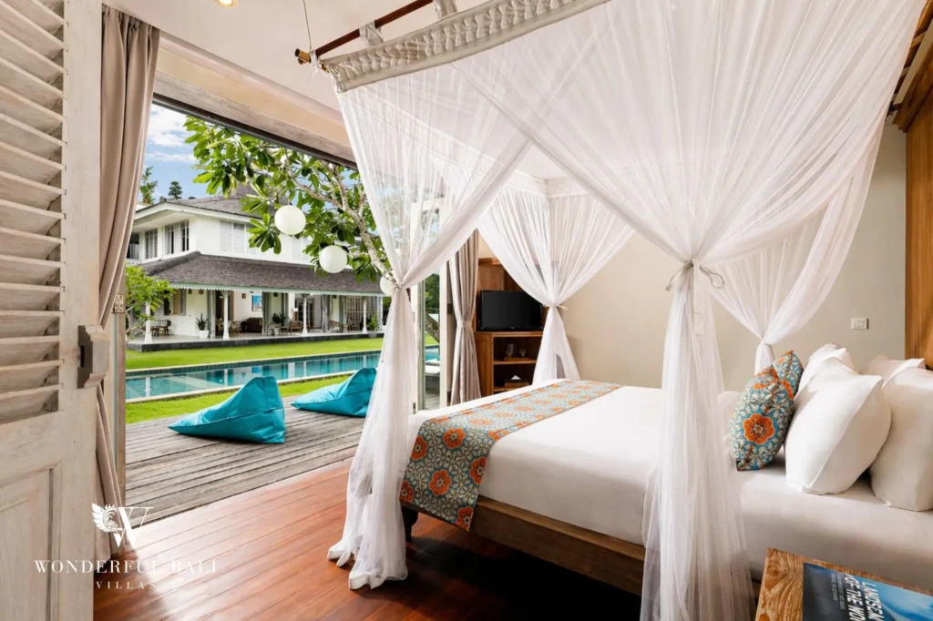 Canopy bedroom opening to the pool with blue bean bags outside, Villa Hasian in Jimbaran