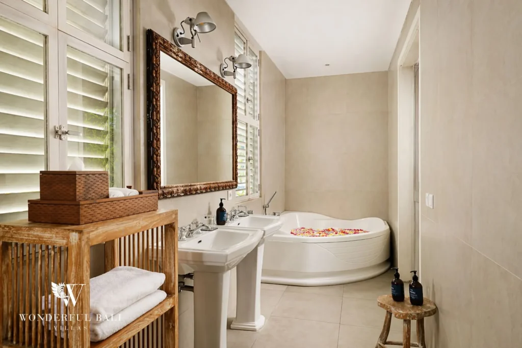 Ensuite bathroom with corner bathtub, pedestal basin and shutter mirror, Villa Hasian in Jimbaran