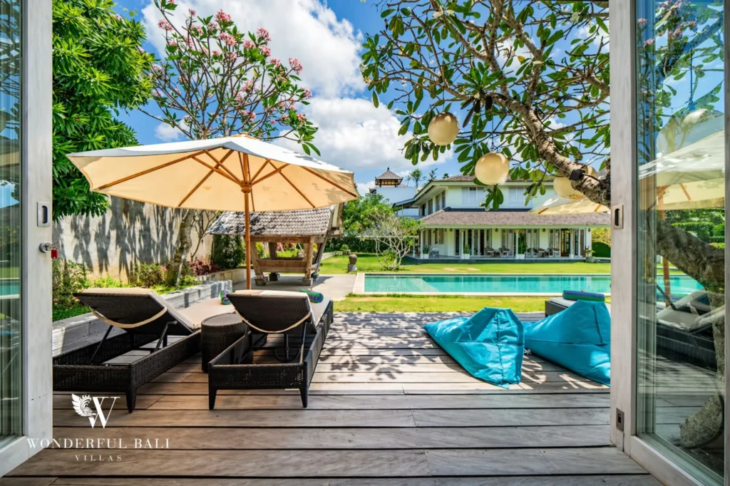 Pool and sun deck viewed from inside a doorway framed by flowers, Villa Hasian in Jimbaran