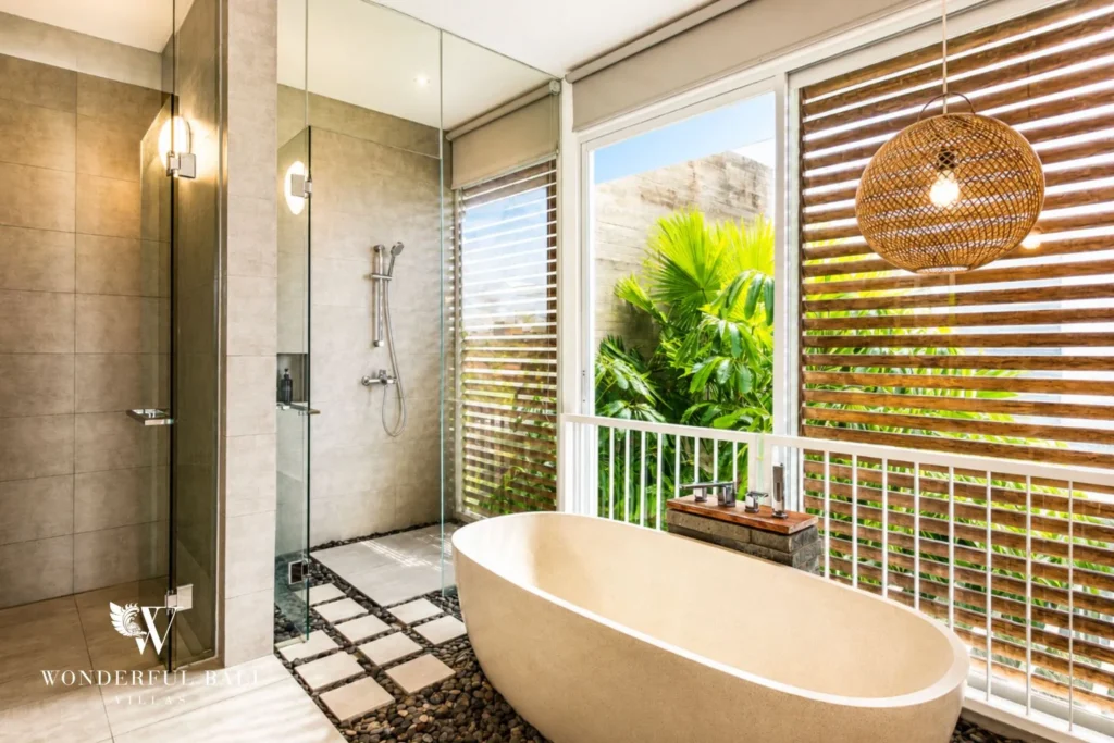 Bathroom with freestanding tub and garden view at a villa in Petitenget, Bali
