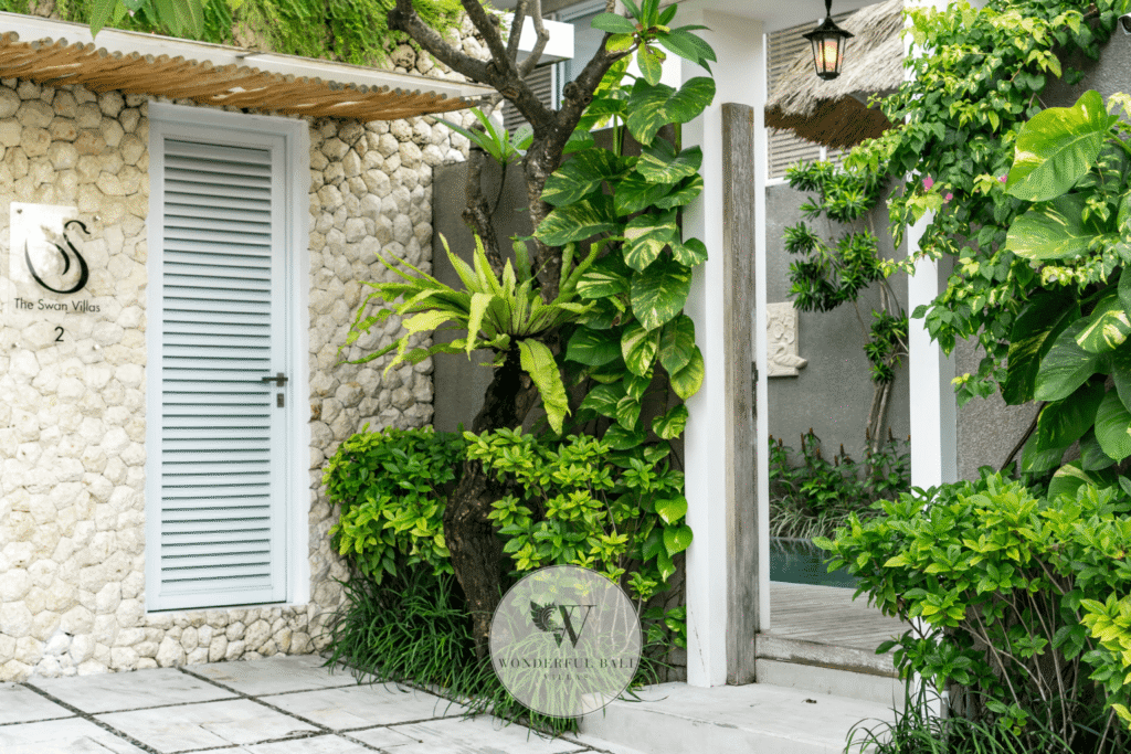 Swan Satu – Grand villa entrance with tropical landscaping and water feature – Seminyak, Bali