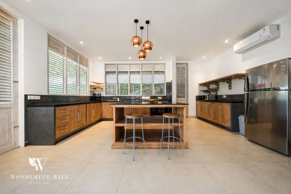 Modern kitchen with central island, wood cabinetry and copper pendant lights, Villa Hasian in Jimbaran