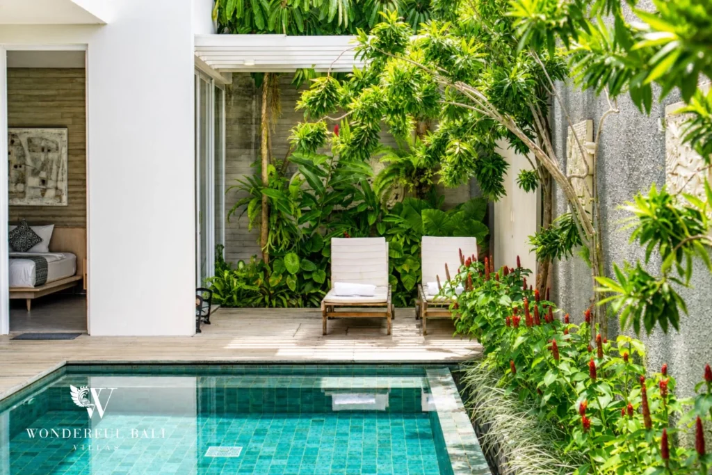 Private pool and tropical garden with loungers at a villa in Petitenget, Bali