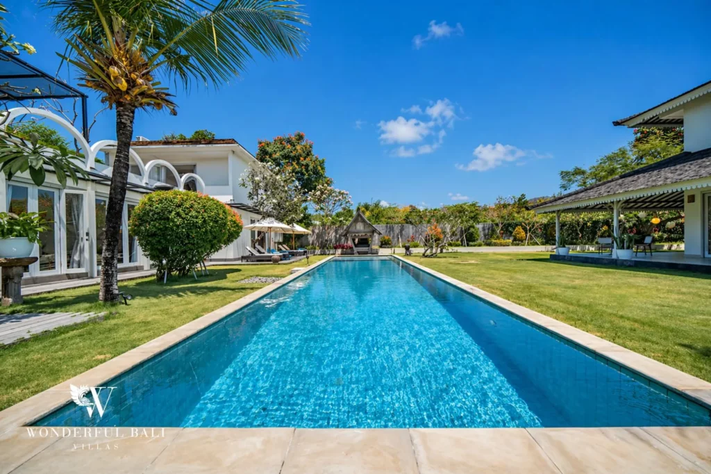 Long private pool stretching the length of the garden with palms, Villa Hasian in Jimbaran