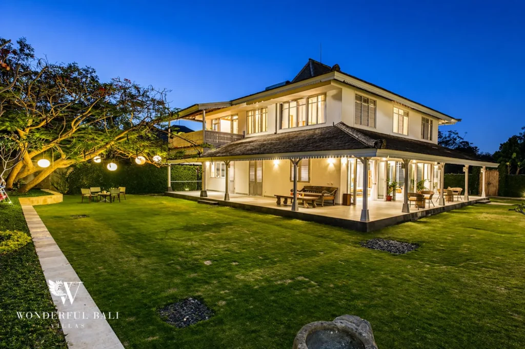 Main house lit from inside at twilight with lanterns in the garden, Villa Hasian in Jimbaran