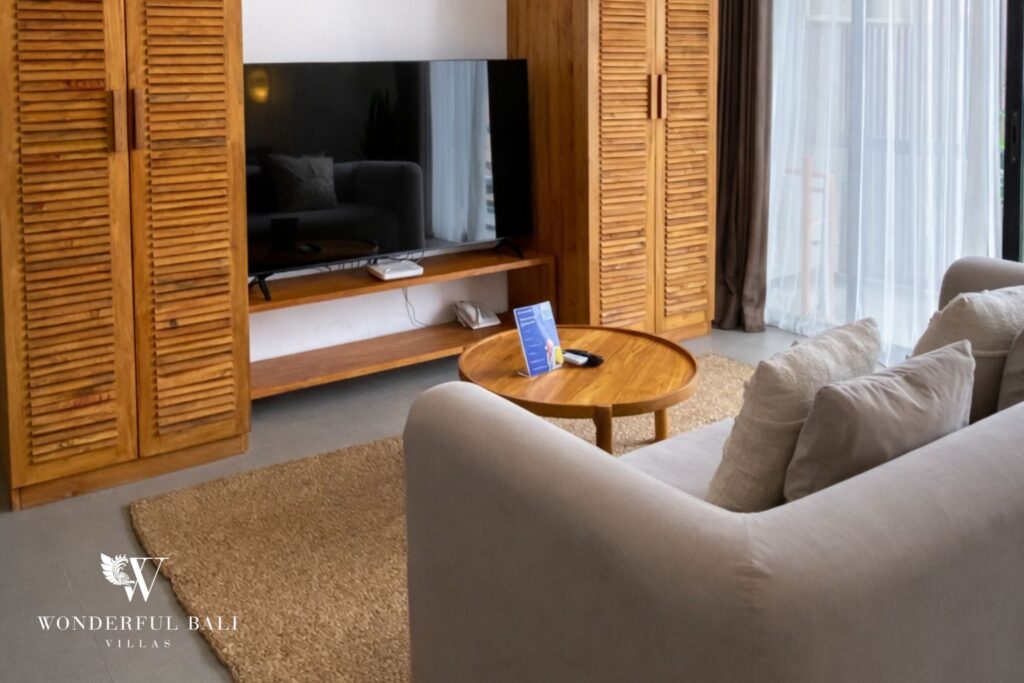 Living area with sofa, smart TV and wooden louvered wardrobes, 1-bedroom studio apartment in Canggu