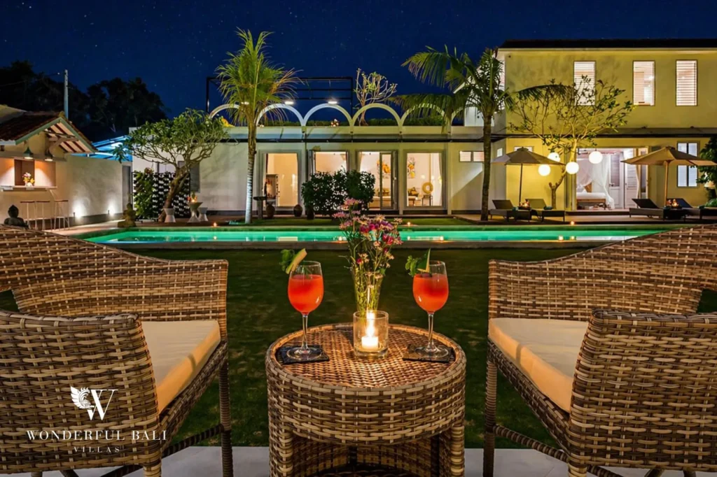 Pool at night with cocktails on a table flanked by rattan chairs, Villa Hasian in Jimbaran