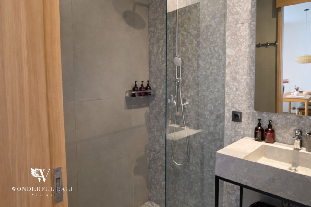 Bathroom with glass walk-in shower and stone vanity, 1-bedroom studio apartment in Canggu