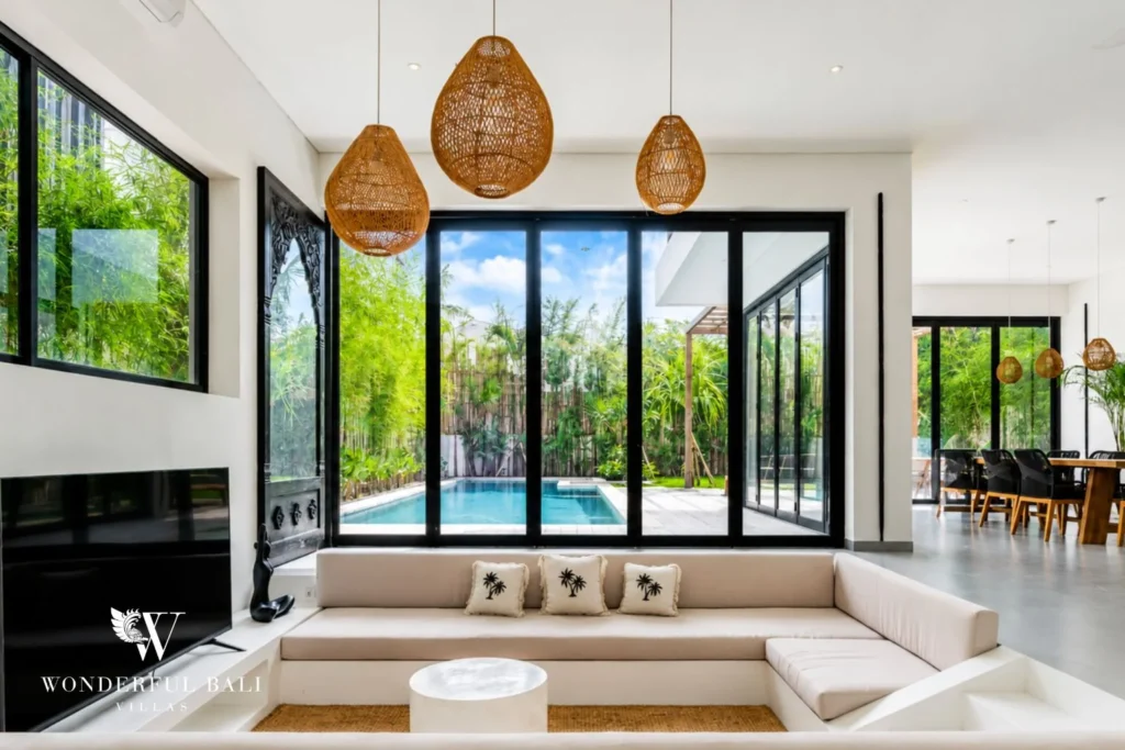 Sunken lounge with rattan pendants and floor-to-ceiling pool view at Luxury 3BR Villa in Pererenan, Bali