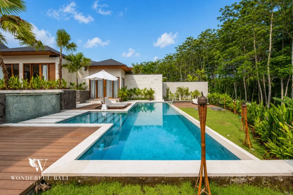 Private pool with timber deck, sunloungers and tropical garden in Tumbak Bayuh, Bali