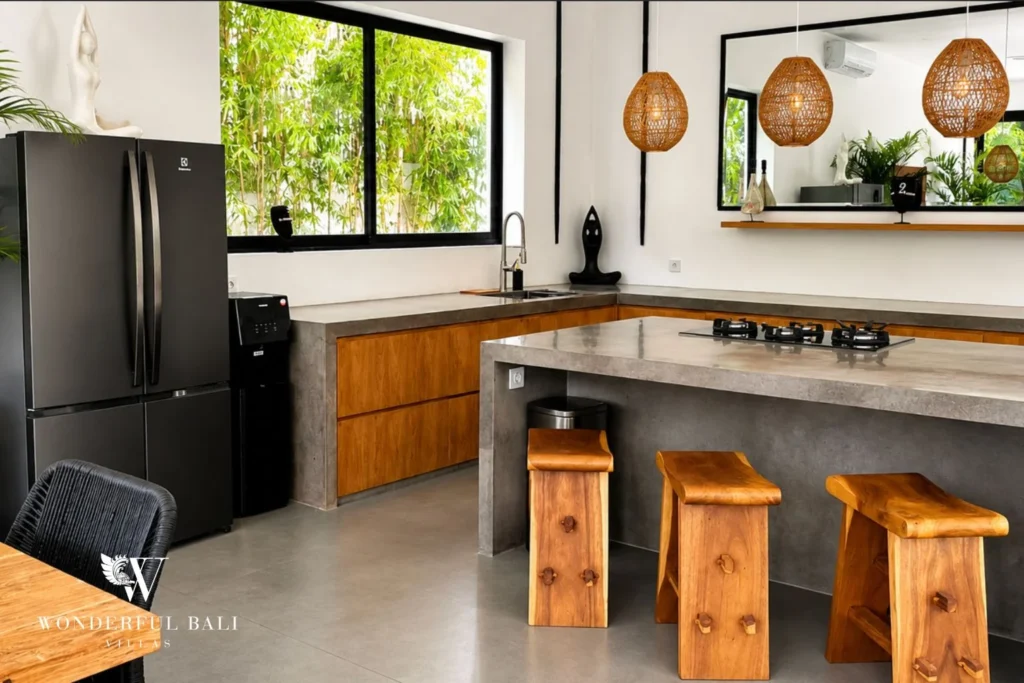 Designer kitchen with concrete island and timber bar stools at Luxury 3BR Villa in Pererenan, Bali