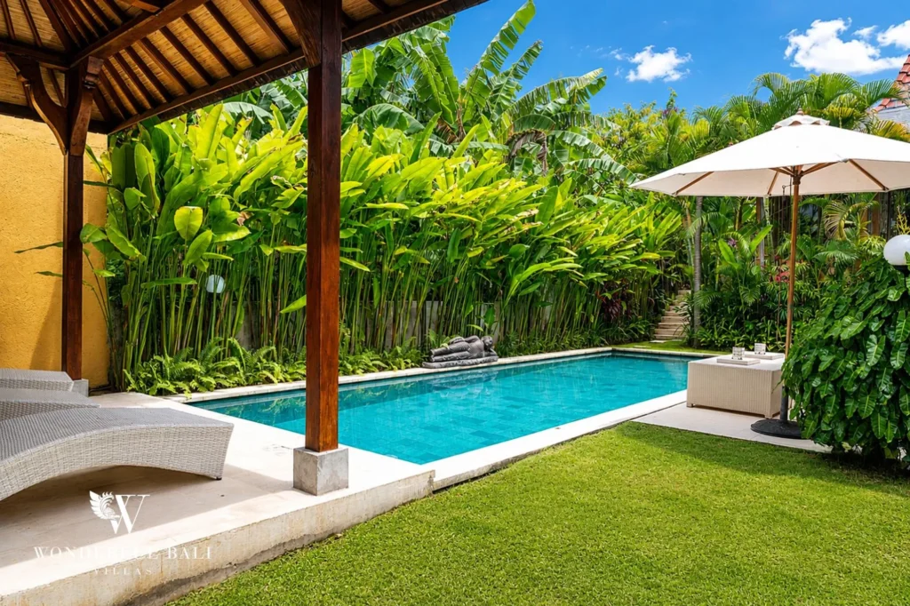 Pool deck with parasol and loungers in daylight, 4-bedroom garden villa in Berawa, Canggu