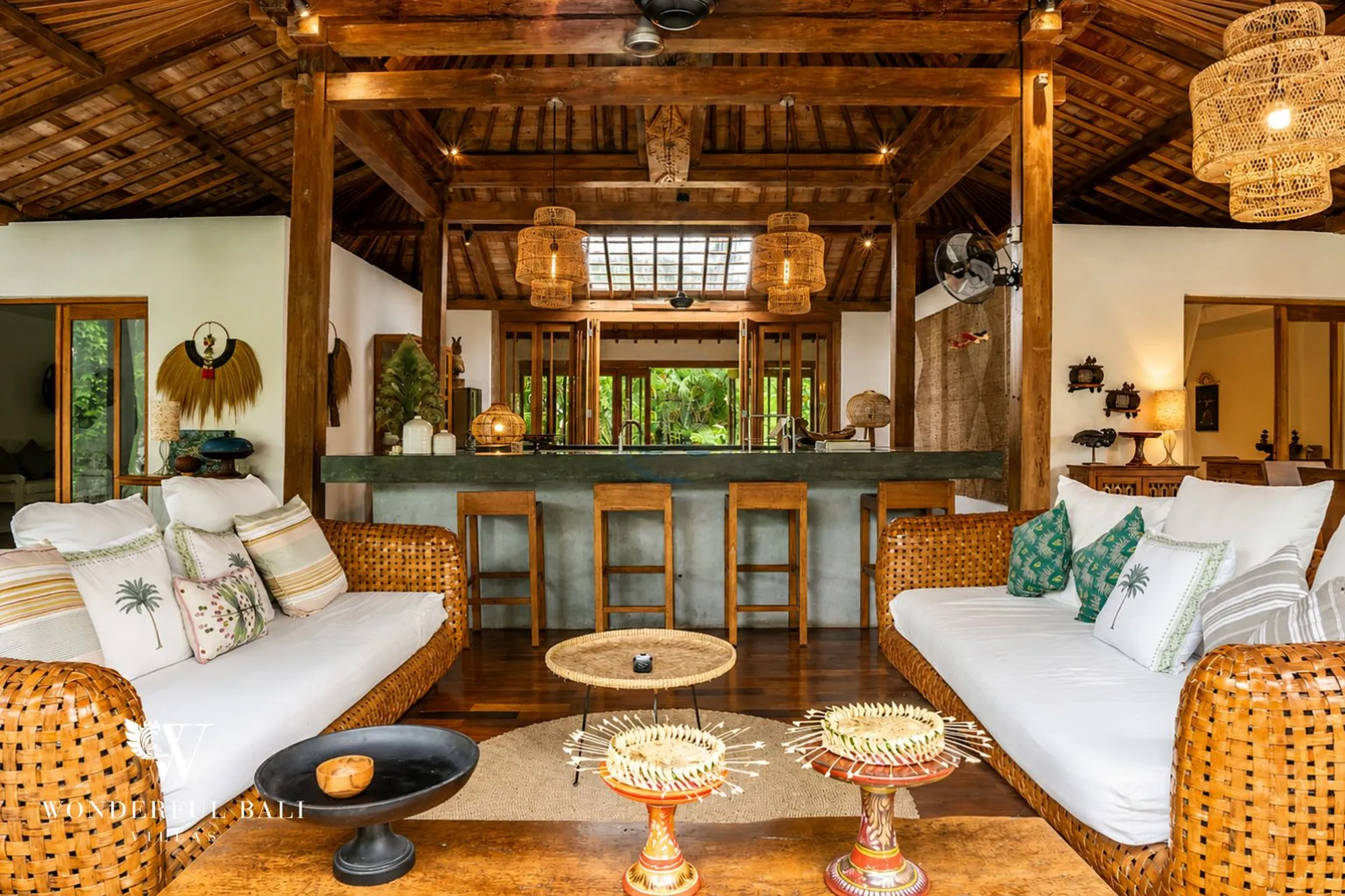 Open dining area under a joglo roof with a view to the pool
