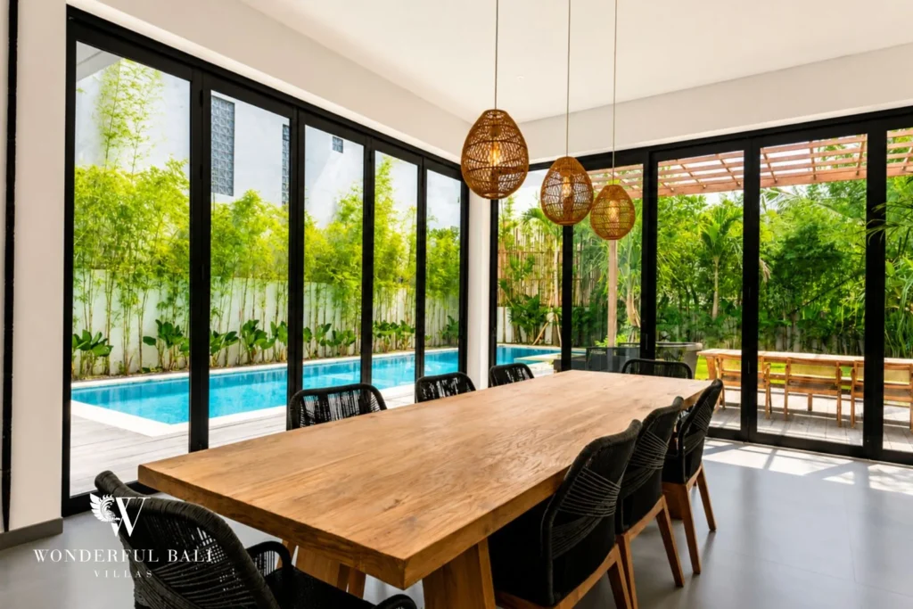 Dining table for ten with rattan pendants and pool view at Luxury 3BR Villa in Pererenan, Bali