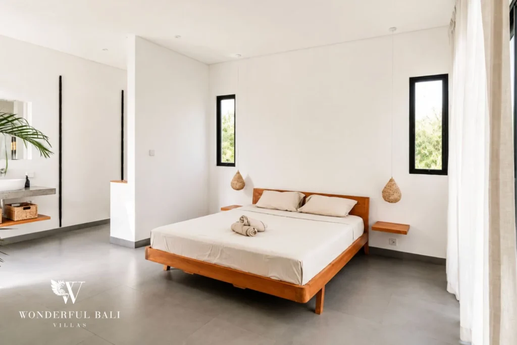 Master bedroom with king bed and adjoining ensuite bathroom at Luxury 3BR Villa in Pererenan, Bali
