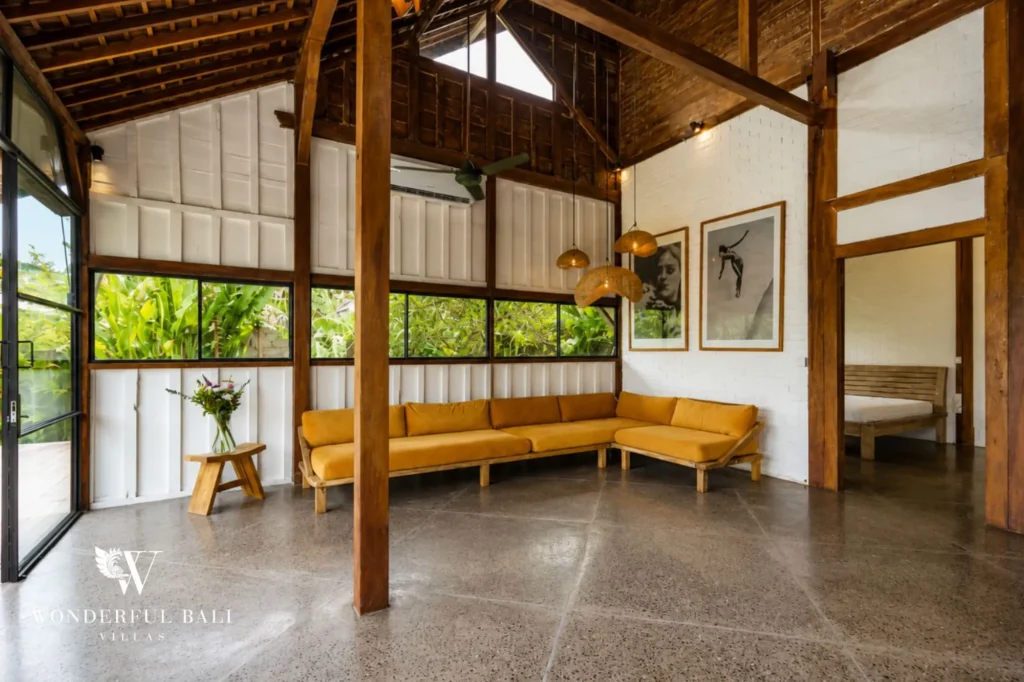 Open wooden living area with floor-to-ceiling glass to the pool deck, dual-villa compound in Pererenan