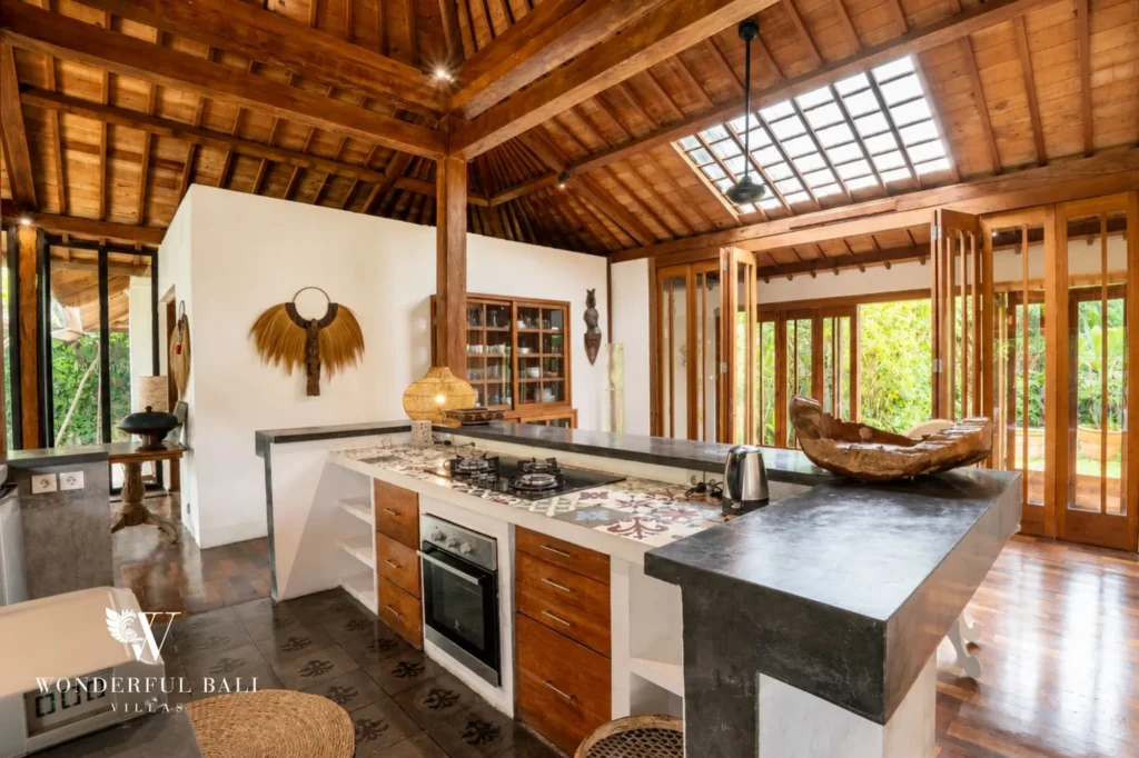 Living area with traditional rugs and bedroom visible beyond, 4-bedroom joglo villa in Umalas