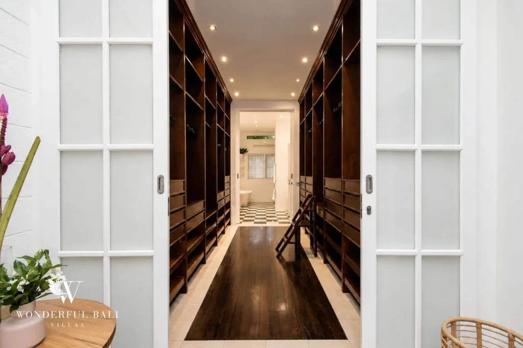 Six-metre walk-through wardrobe between master and second bedroom with custom hangers, 3-bedroom colonial villa in Umalas