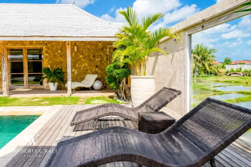 Pool view with sun loungers and tropical garden, 4-bedroom family villa in Mertasari, Kerobokan