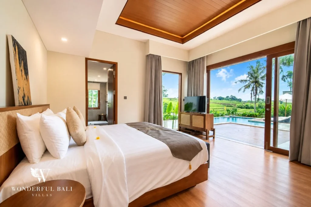 Bedroom with sliding doors to pool and rice field view in Tumbak Bayuh, Bali