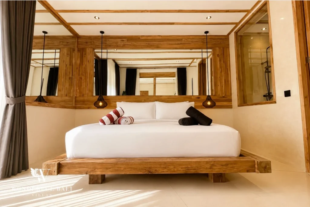 Master bedroom with mirror-clad wall and timber platform bed in Berawa, Bali