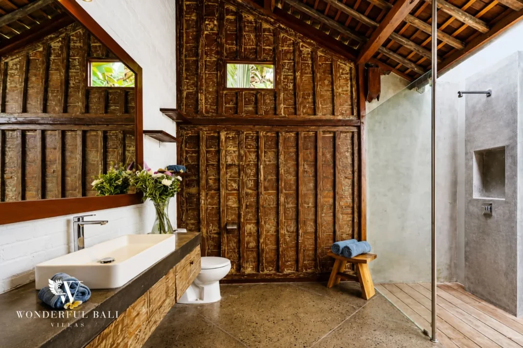 Open-air wooden bathroom with bathtub and stone vanity, dual-villa compound in Pererenan