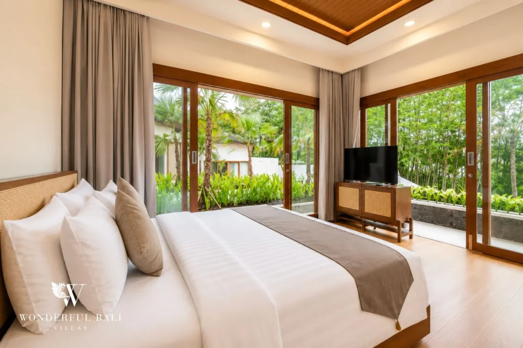 Bedroom with glass doors to tropical bamboo garden in Tumbak Bayuh, Bali