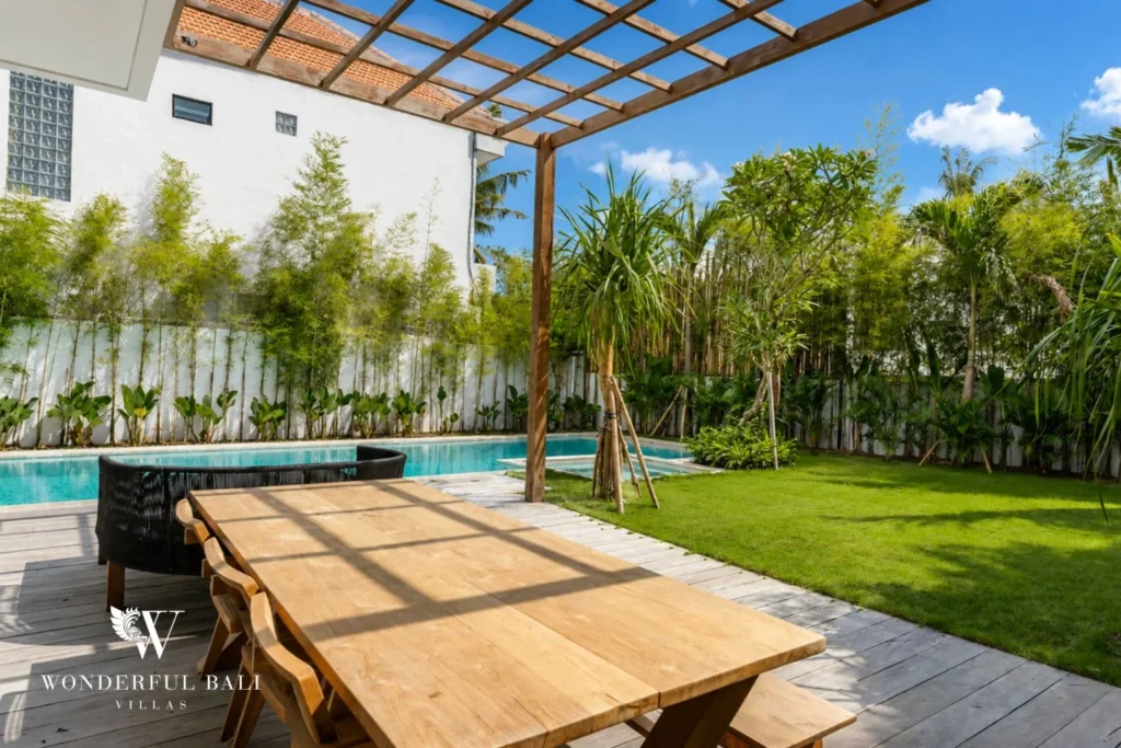 Outdoor dining under pergola with pool and lawn view at Luxury 3BR Villa in Pererenan, Bali