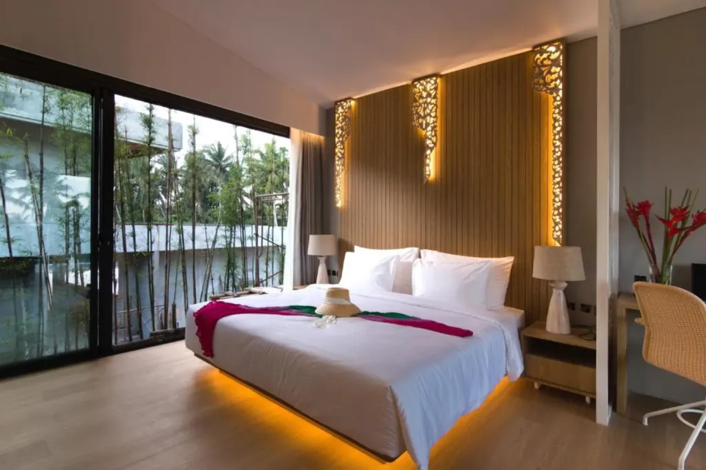 Villa Umahan, Ubud — bedroom, primary bedroom with carved wood headboard panels and bamboo view, Villa Umahan