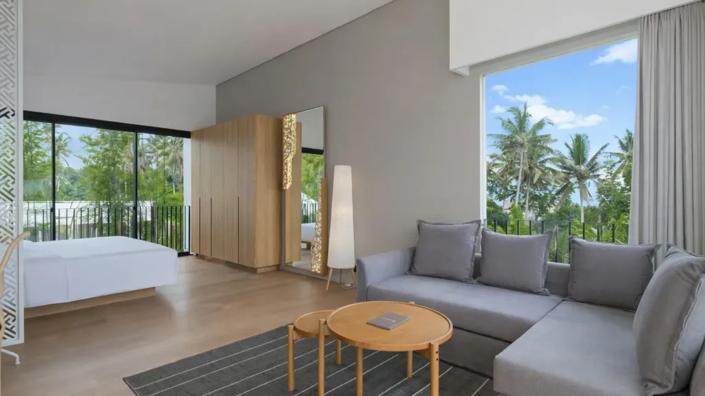 Villa Umahan, Ubud — bedroom, sitting area, sofa and pool view through full-height windows, Villa Umahan