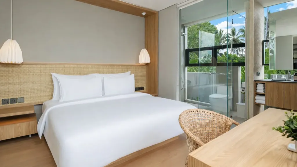 Villa Umahan, Ubud — bedroom, rattan headboard and ensuite bathroom visible through balcony doors, Villa Umahan