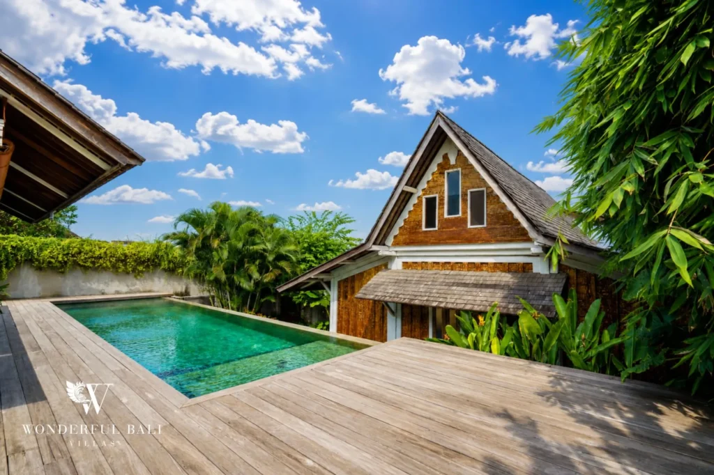 View across the pool to the A-frame timber villa, dual-villa compound for sale in Pererenan