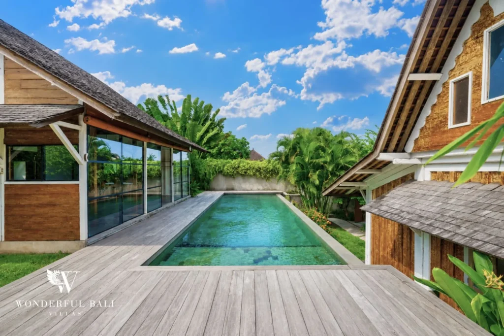 Wide view of the pool, deck and timber villa, 4-bedroom dual-villa compound in Pererenan