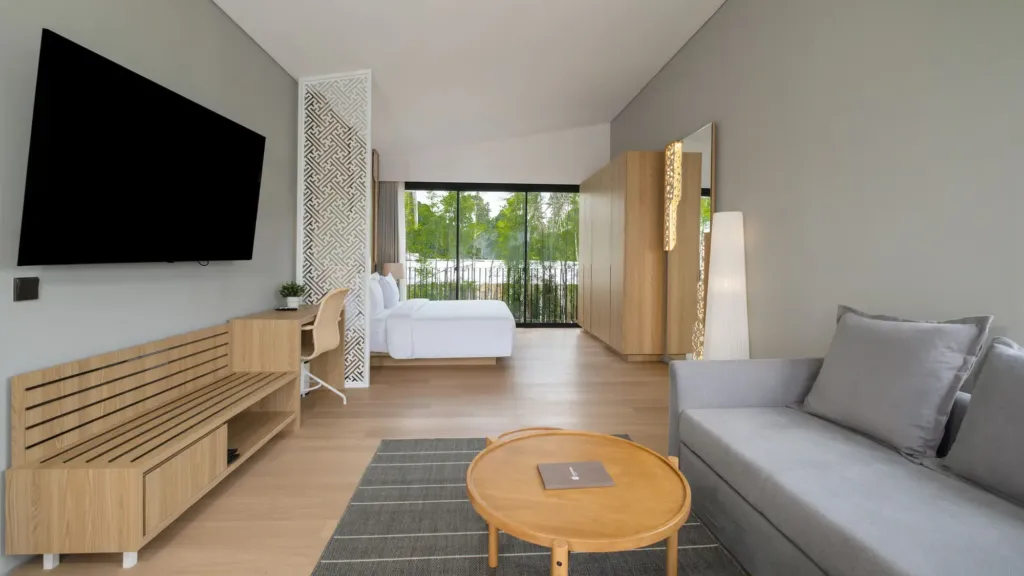 Villa Umahan, Ubud — bedroom, TV, sitting area and carved partition behind the bed, Villa Umahan