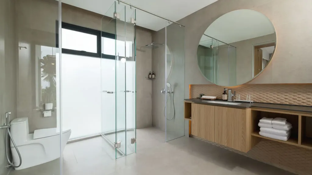 Villa Umahan, Ubud — bathroom, round mirror, glass walk-in shower and timber vanity, Villa Umahan