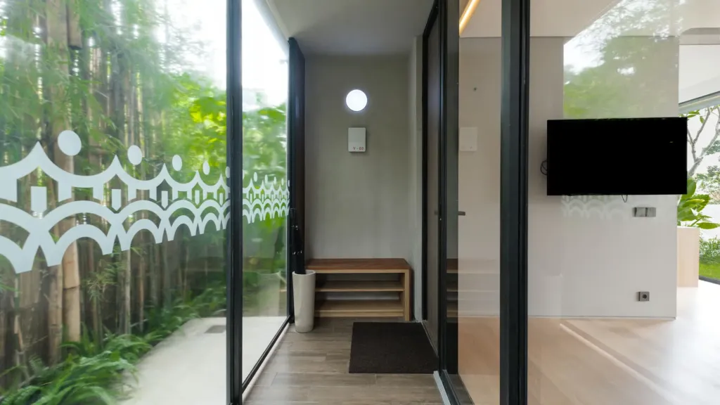 Entry hallway with bench and etched bamboo-pattern glass, Villa Umahan in Ubud