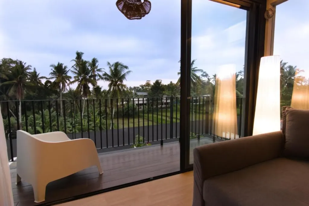 Villa Umahan, Ubud — balcony, evening with chair and view over palms and treetops, Villa Umahan