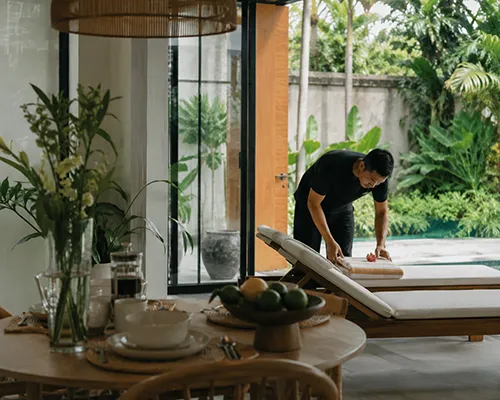 Wonderful Bali Villas staff preparing the pool area at dusk