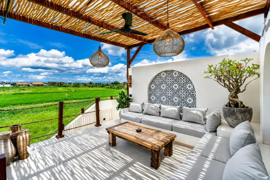 Open-air terrace with sofa overlooking rice fields at villa in Seseh, Bali