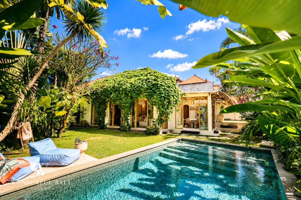 Pool with floating daybed framed by lush jungle garden at villa in Berawa, Bali