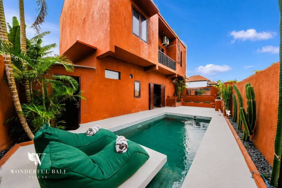 Private pool with green beanbags and terracotta villa facade in Nyanyi, Bali