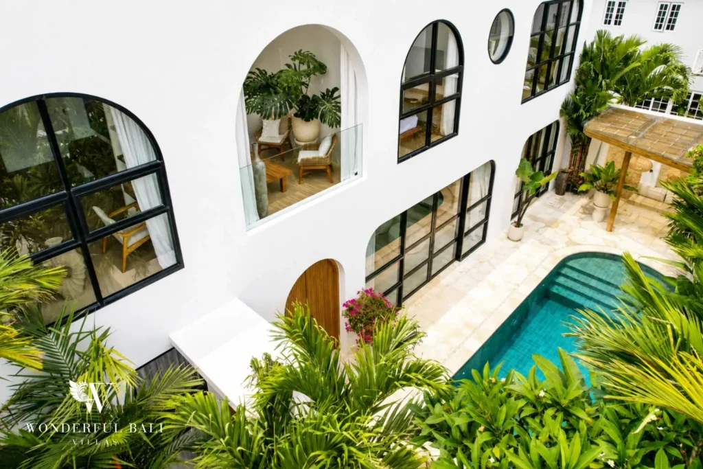 White villa exterior with arched windows beside the pool at villa in Umalas, Bali