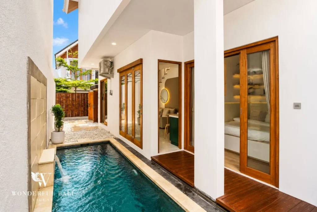 Narrow lap pool in a courtyard with glass doors at villa in Denpasar, Bali