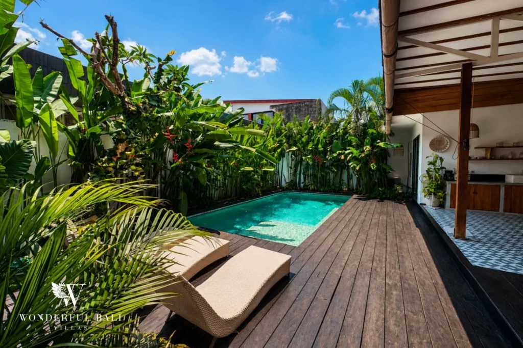 Pool with daybed on a timber deck beside the garden at villa in Canggu, Bali