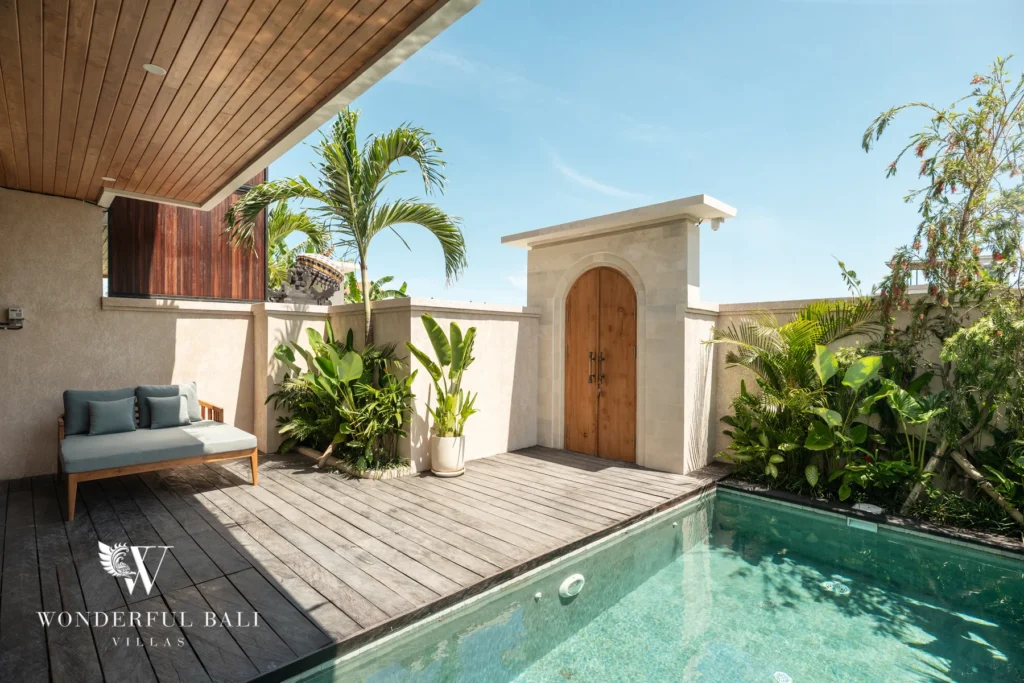 Pool and timber deck with arched feature wall at villa in Umalas, Bali