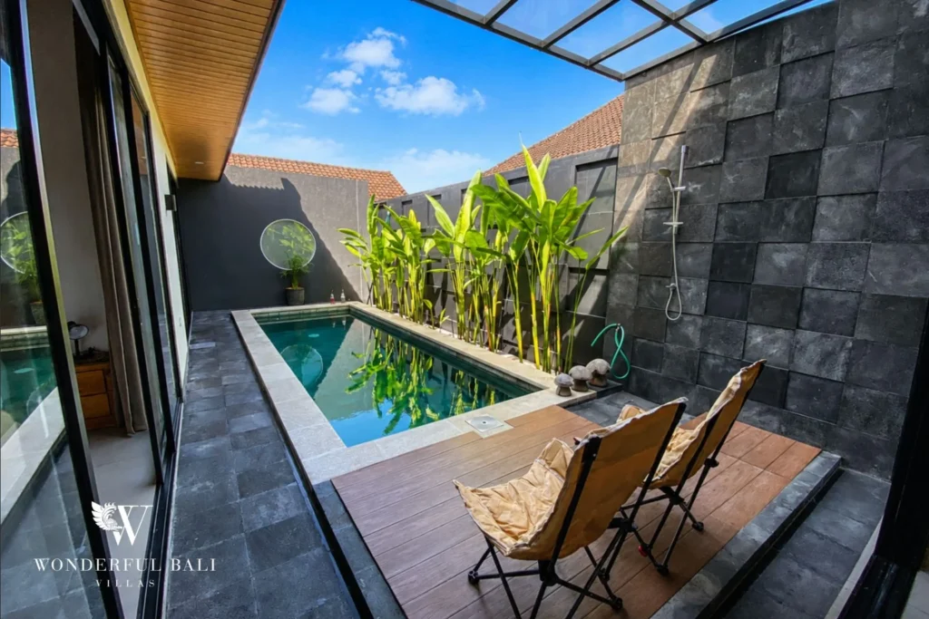 Private pool with outdoor shower and tropical planting at villa in Canggu, Bali