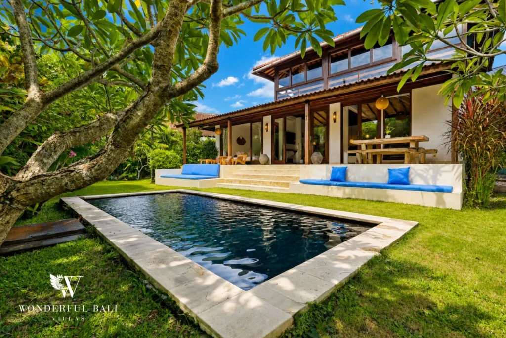 Pool with stepping stones framed by tropical garden and palms at villa in Umalas, Bali